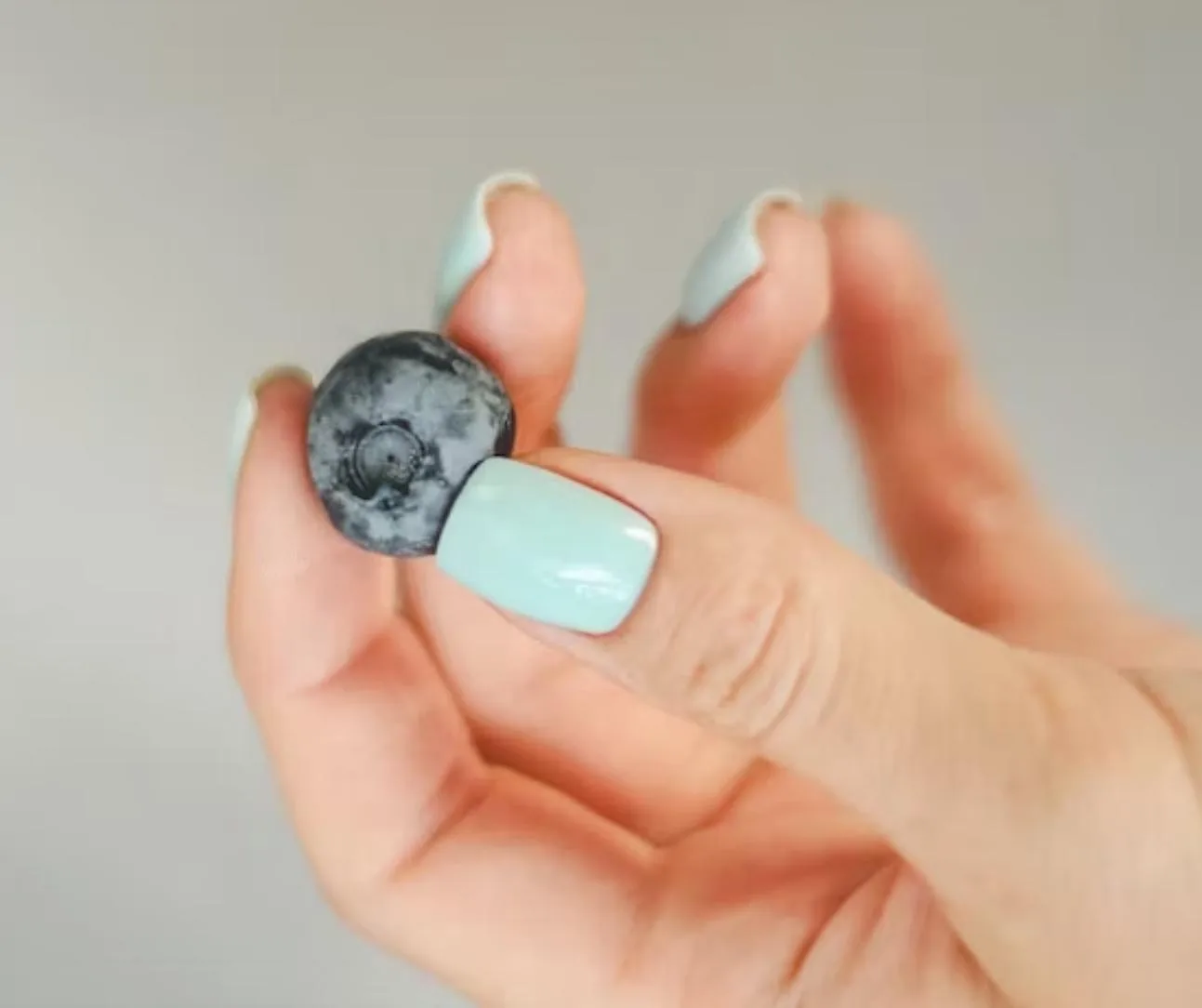 Pale mint square nails on grey background