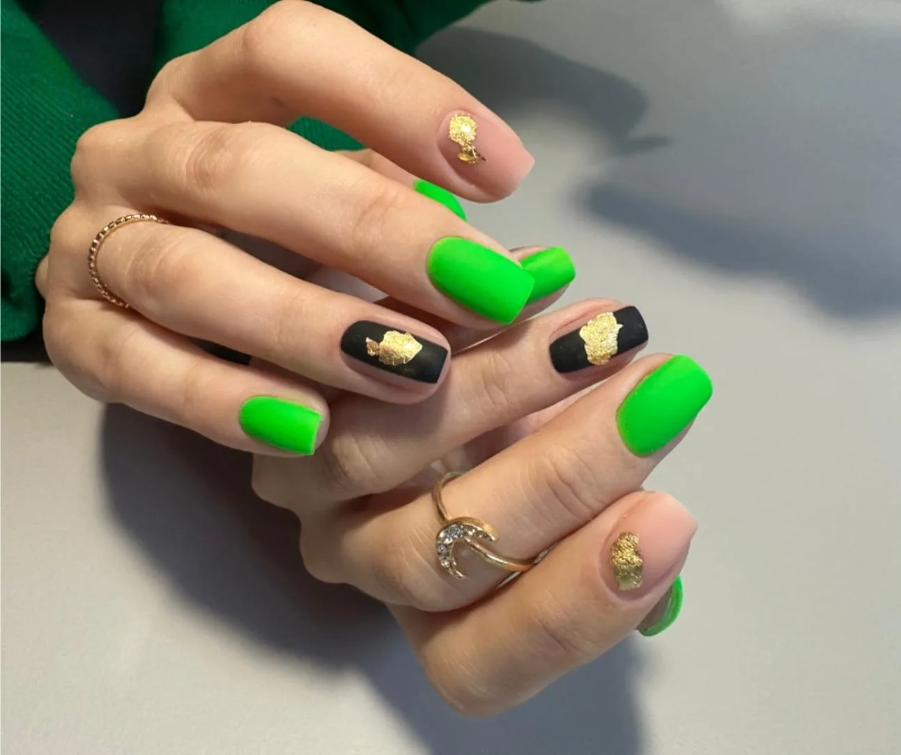 Neon-green matte-black and gold-leaf nail art