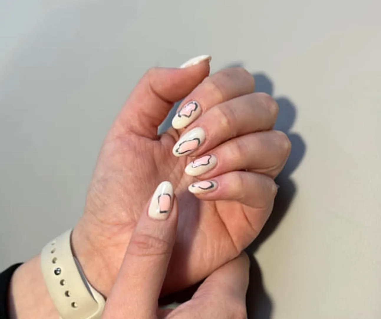 Nude almond nails with pink and black cloud line art